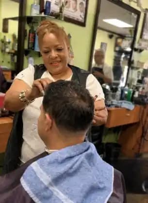 Lupita working with a client at Tijeras Barbershop