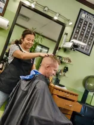 Cristal finishing a client’s haircut at Tijeras Barbershop